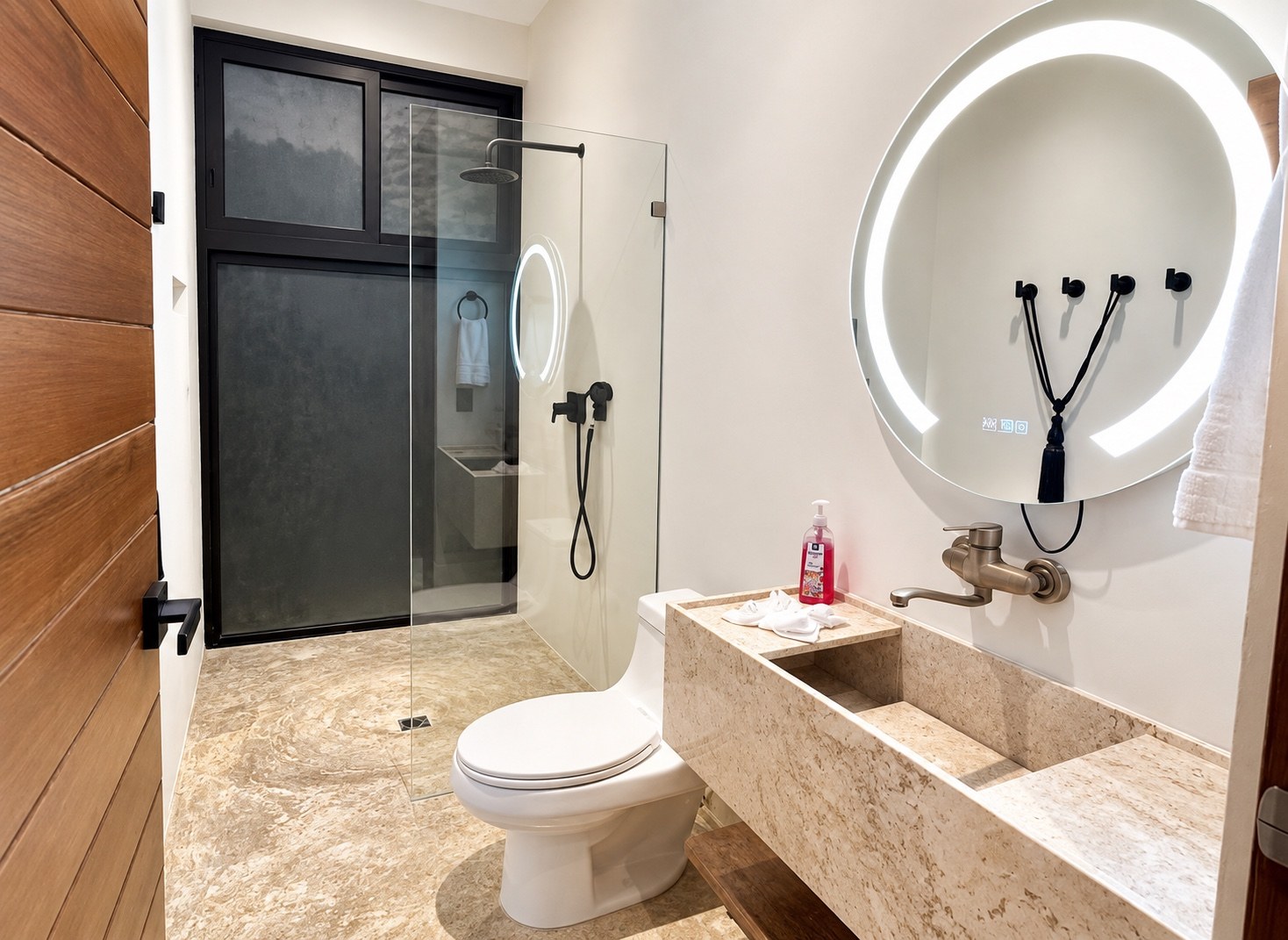 Bathroom with illuminated round mirror and glass shower