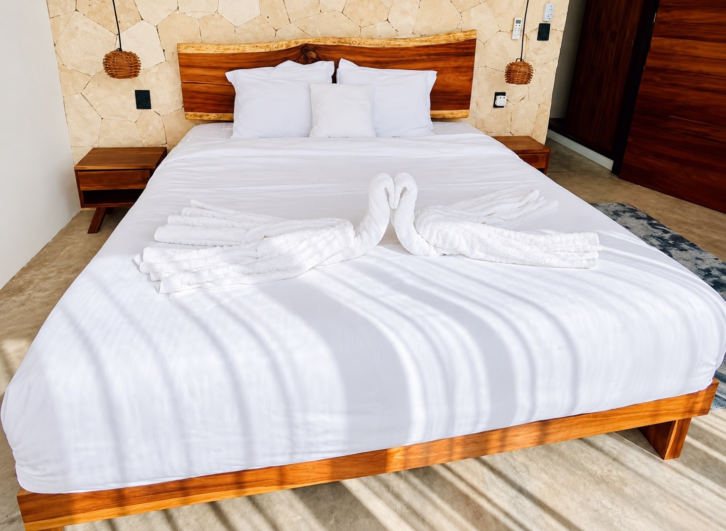 King bed with white linens and towel swans